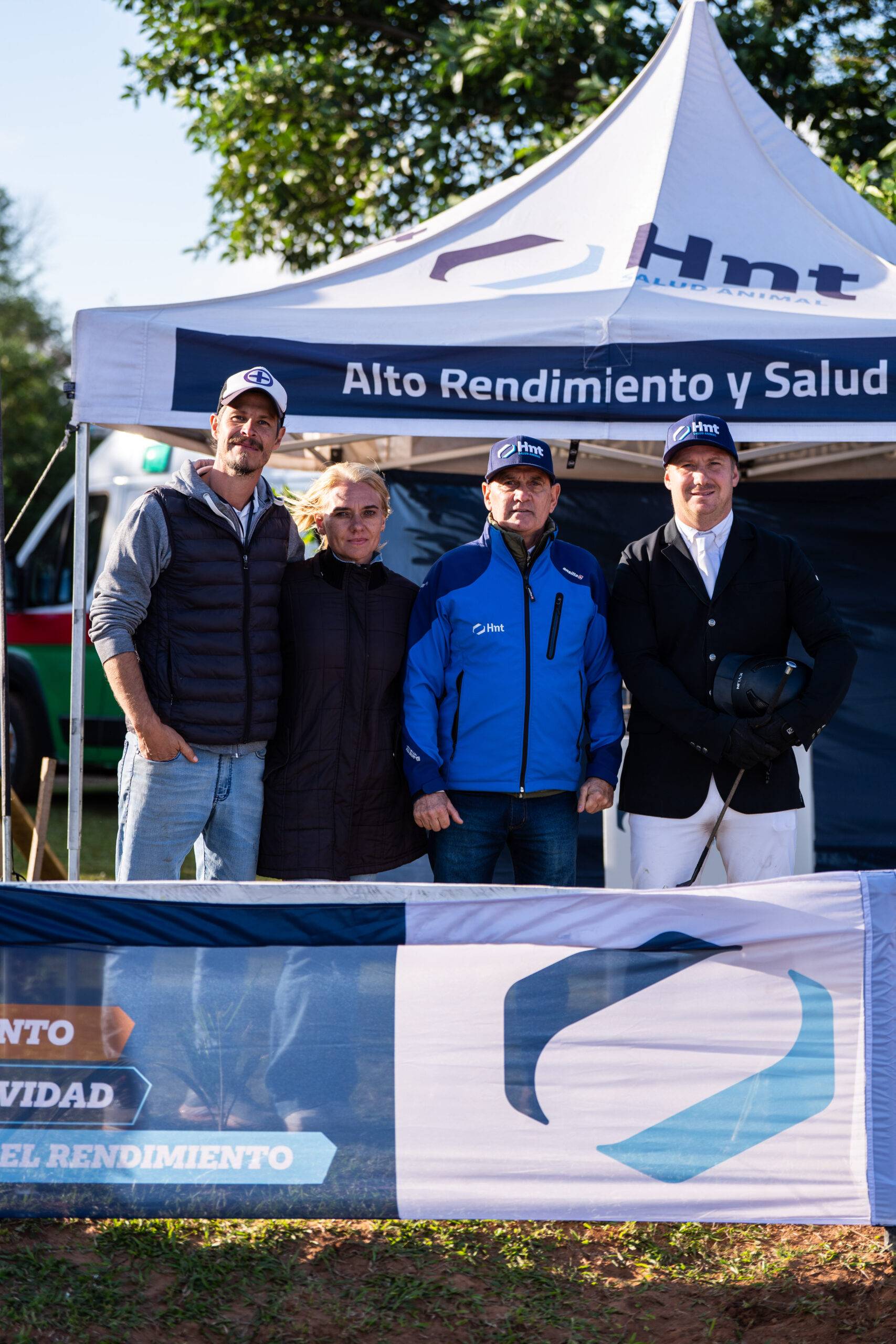 Equipo de Hípico El Palenque junto al stand de Laboratorio HNT en el Torneo Valla Uno del Hípico Casco Rosado de Posadas
