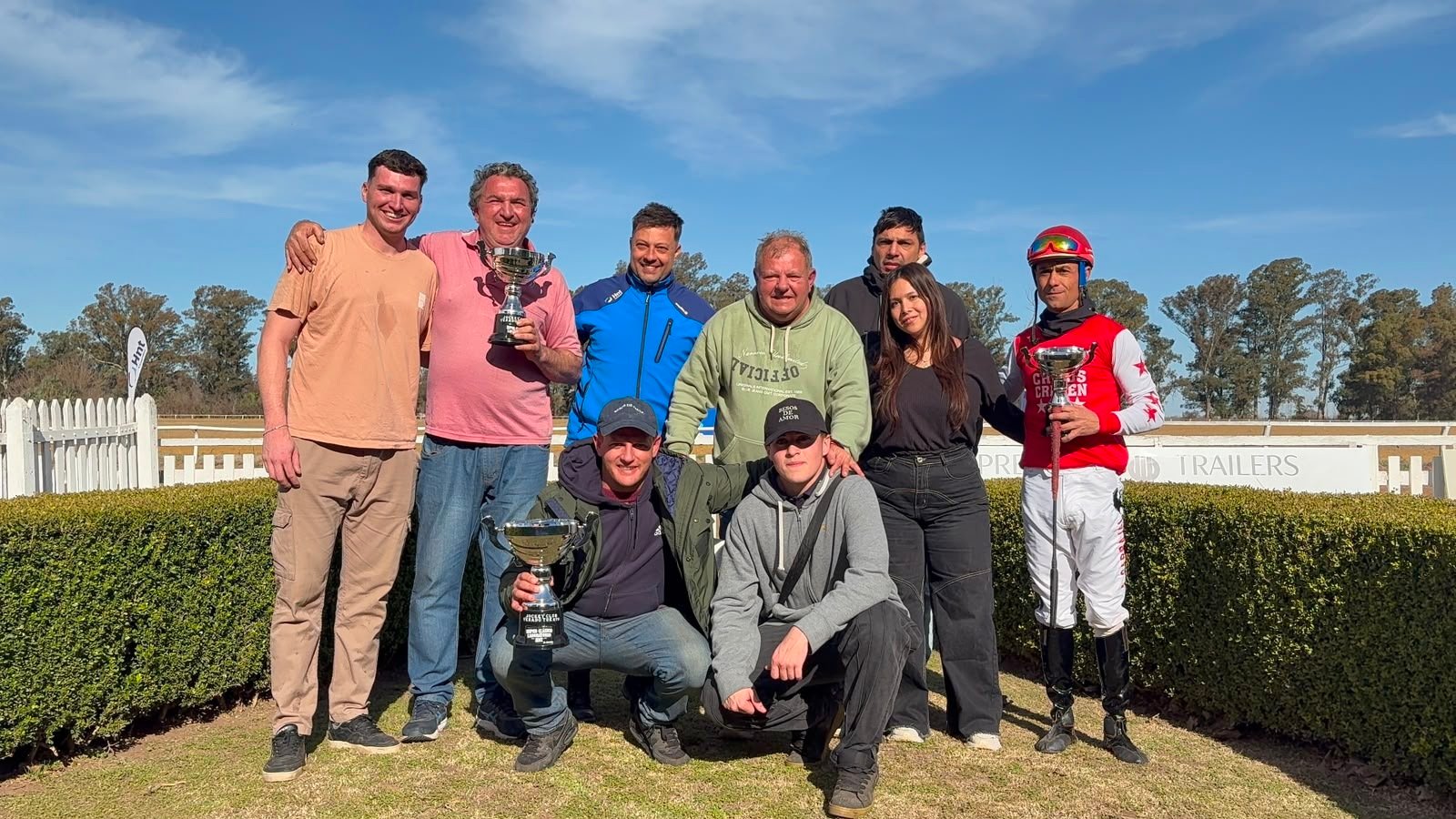El equipo completo del Stud Don Romeo posa con las copas del Súper Clásico Laboratorio HNT junto al jockey Alexis Carbajal