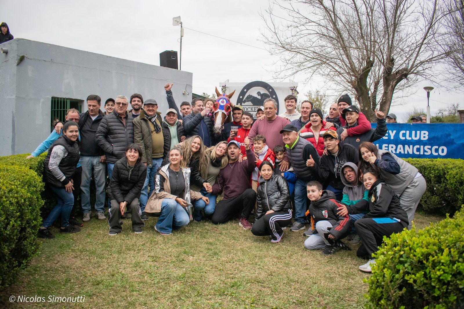 Festejo del stud ganador junto a la yegua frente al cartel del Jockey Club San Francisco tras la Copa HNT