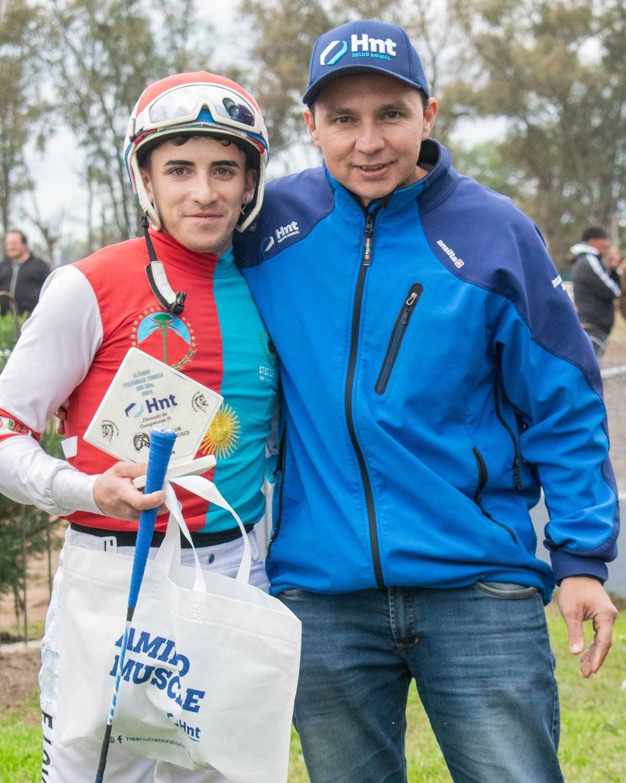 El jockey ganador recibe la placa del Laboratorio HNT junto a un representante del laboratorio en San Francisco