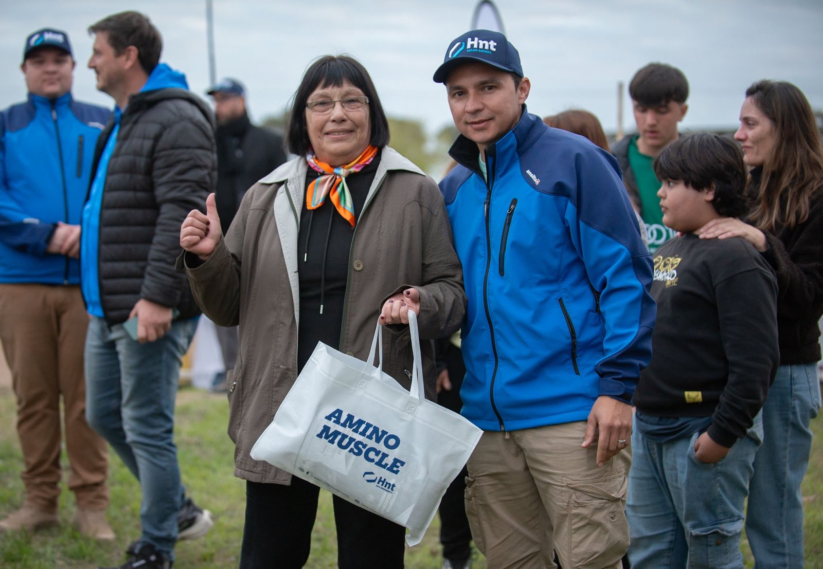 Aficionados con la bolsa de AminoMuscle y la gorra del Laboratorio HNT en la jornada de trote en el Hipódromo de Devoto