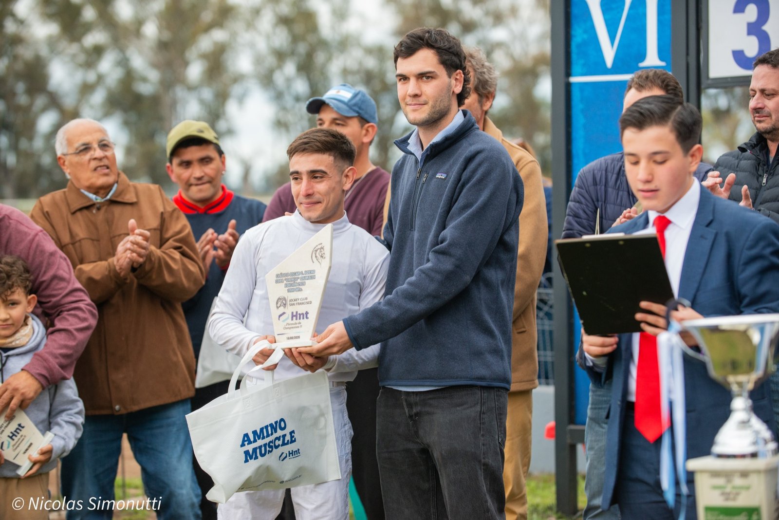 El jockey Mauricio Villaruel recibe la plaqueta y el bolso AminoMuscle del Laboratorio HNT en San Francisco