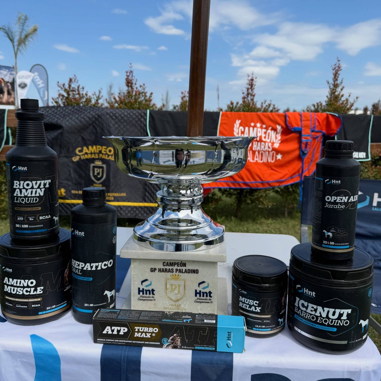 Productos del Laboratorio HNT junto a la copa de campeón del Gran Premio Haras Paladino