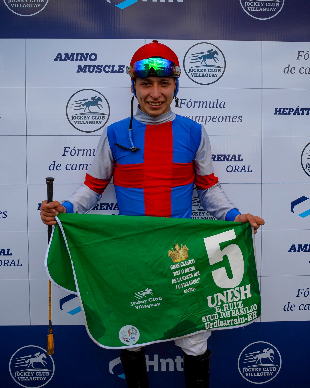Miguel Rodríguez con la manta verde de ganador de Unesh en el Jockey Club Villaguay